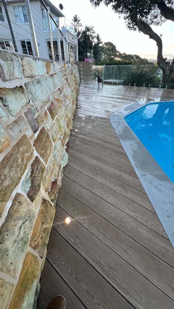 Pool surround composite decking with sandstone wall and LED lights - Castlecrag Sydney