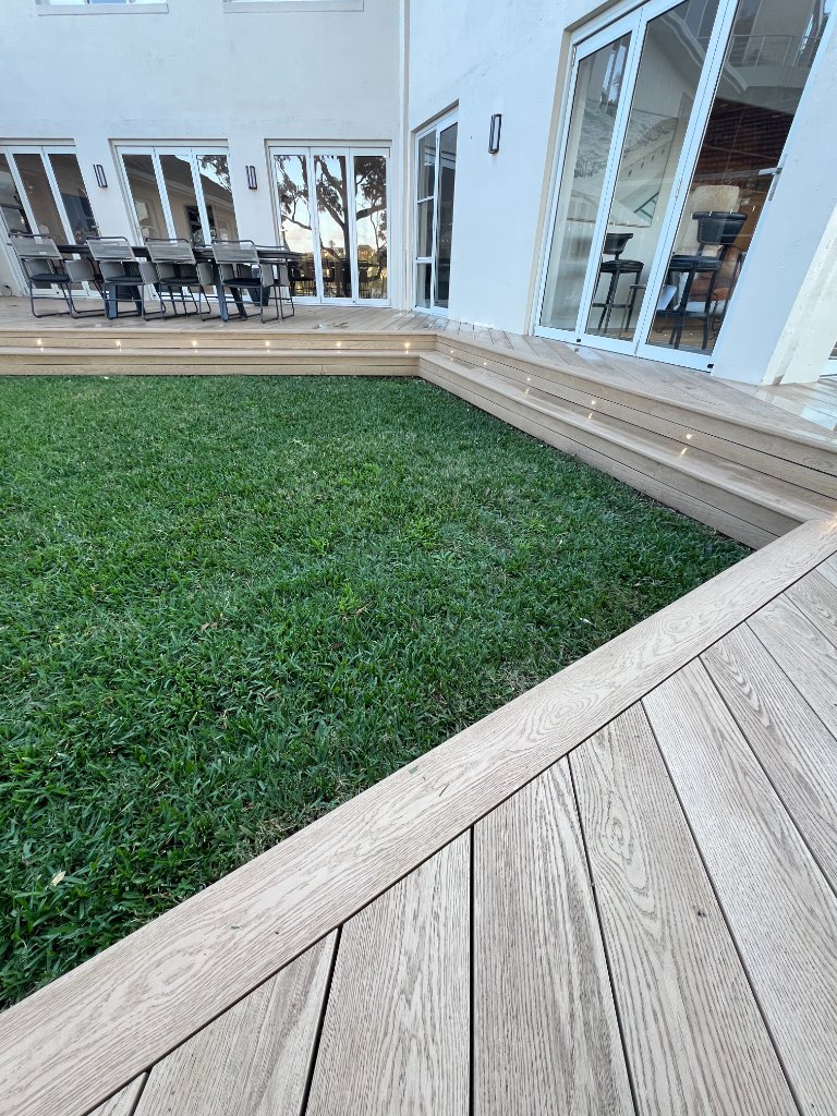 Multi-level composite deck with step lighting surrounding lawn - Castlecrag North Shore Sydney