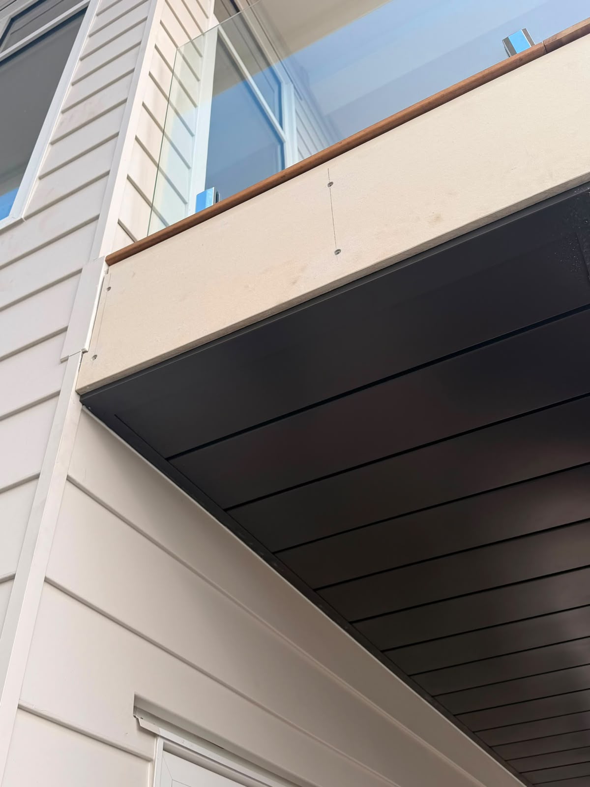 Close-up of dark linear soffit lining showing batten spacing