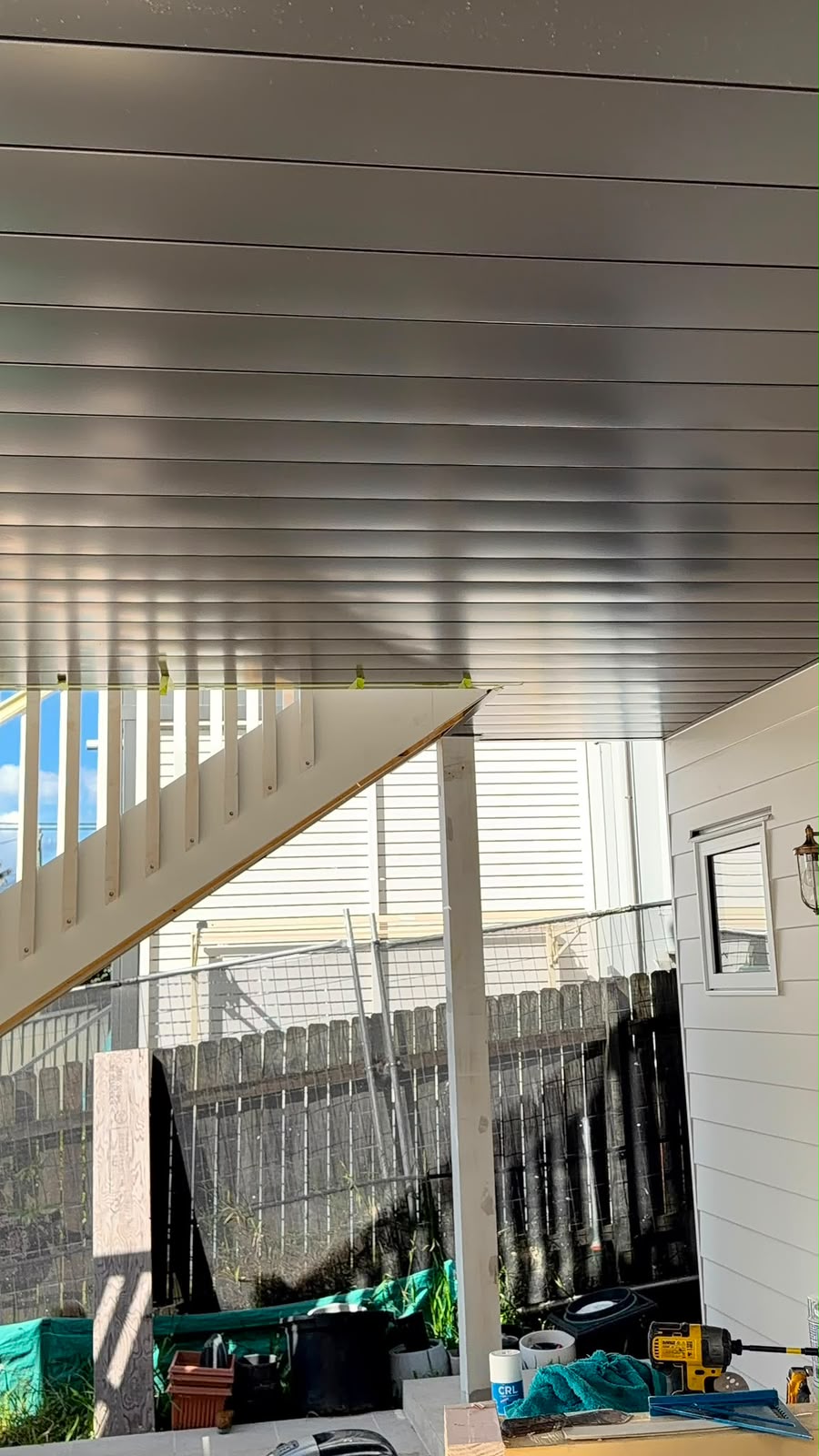 Staircase alongside finished wall cladding and wall light fixture